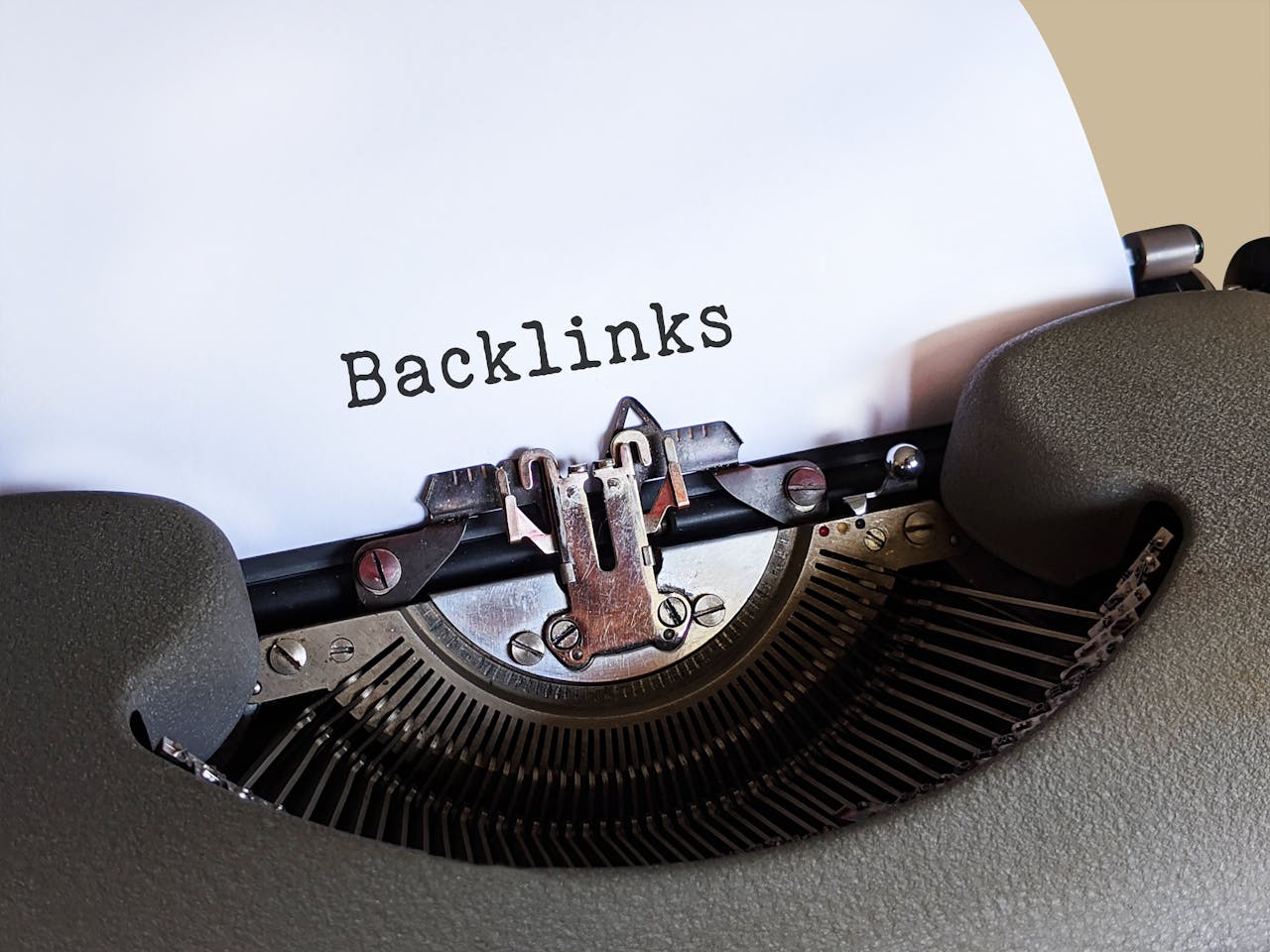 gallery-4 Close-up of a vintage typewriter printing the word 'Backlinks,' emphasizing content and SEO concepts.