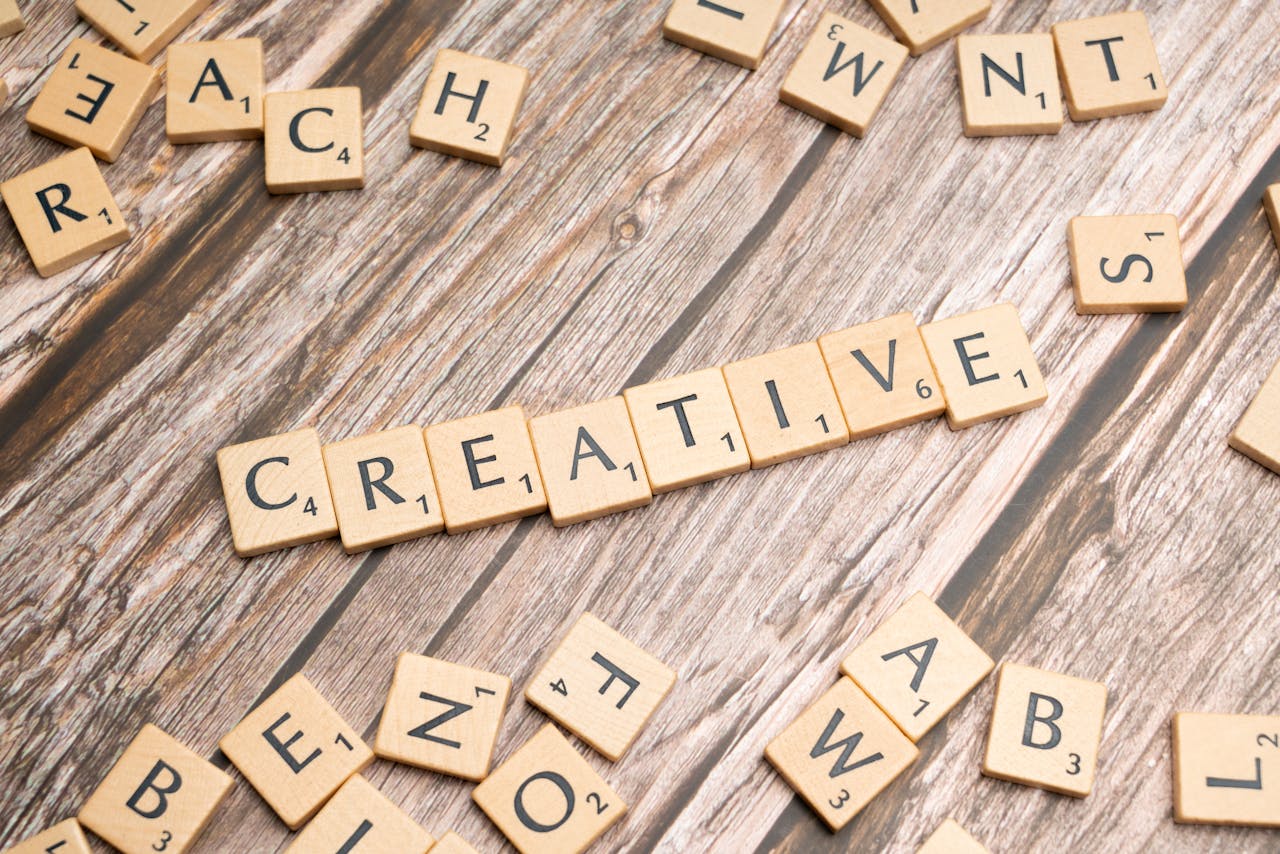 hero-img-01 Wooden tiles on a rustic background spelling the word 'creative'.